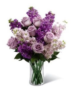 Lavender colored flowers and roses for Valentines day in a clear vase